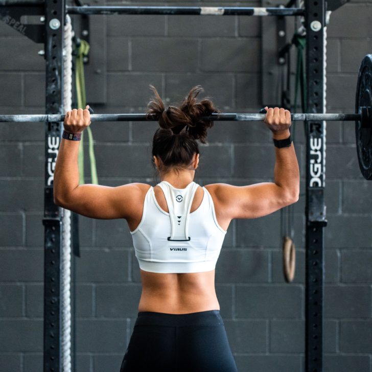 woman using a barbell for overhead presses