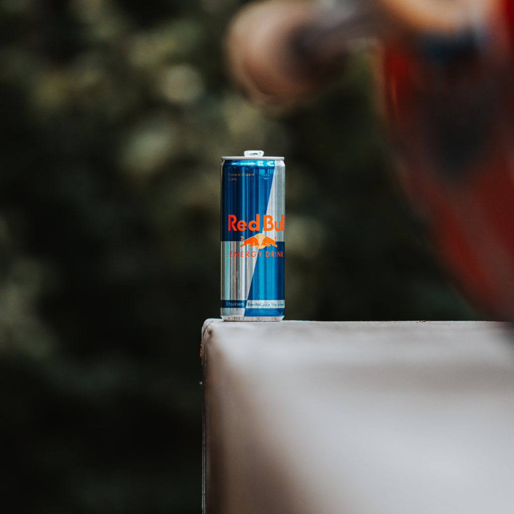 close up of a red bull energy drink with the background blurred