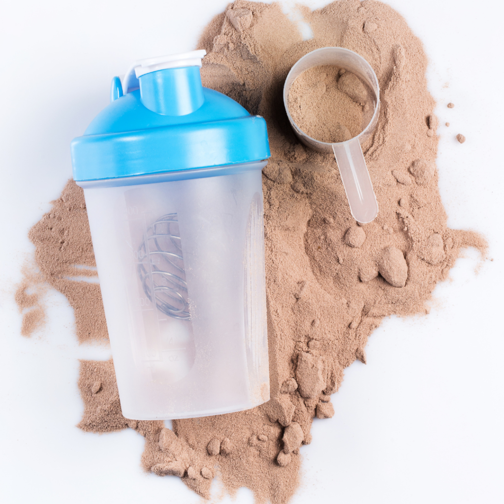 protein powder scoop and a water bottle on top of more protein powder