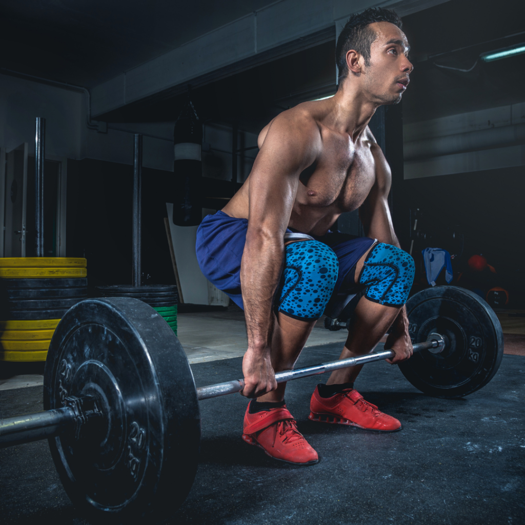 man in blue shorts and red shoes deadlifting