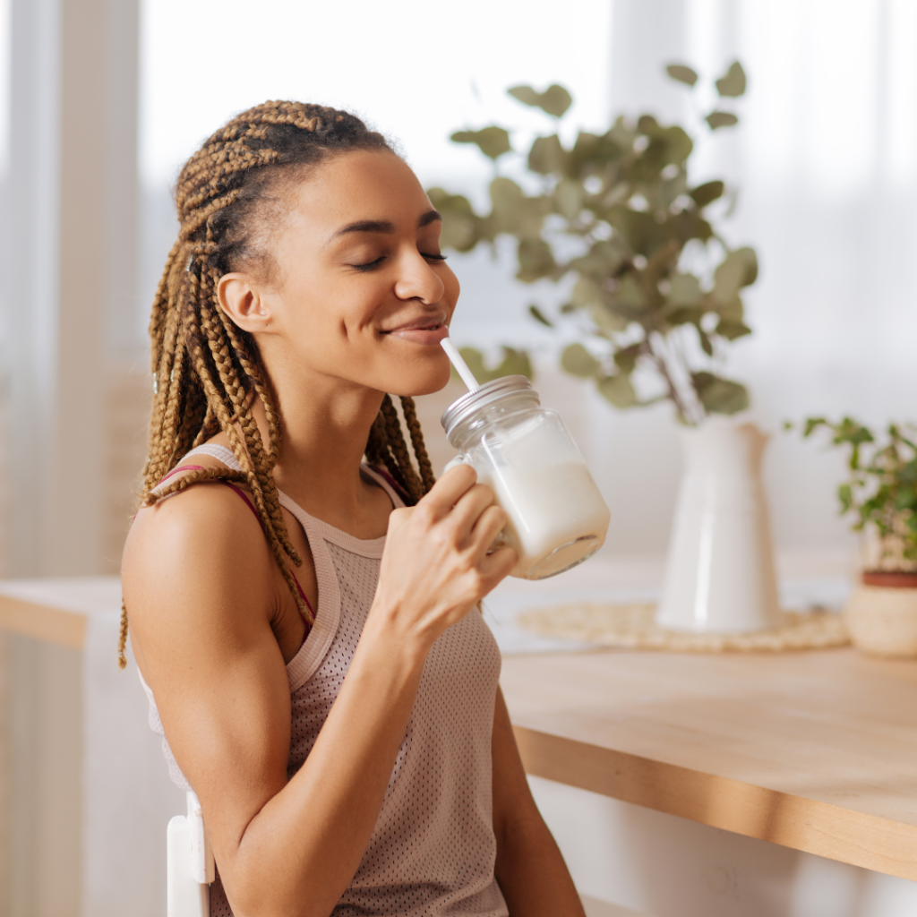 woman enjoying a protein shake in a cup with a straw