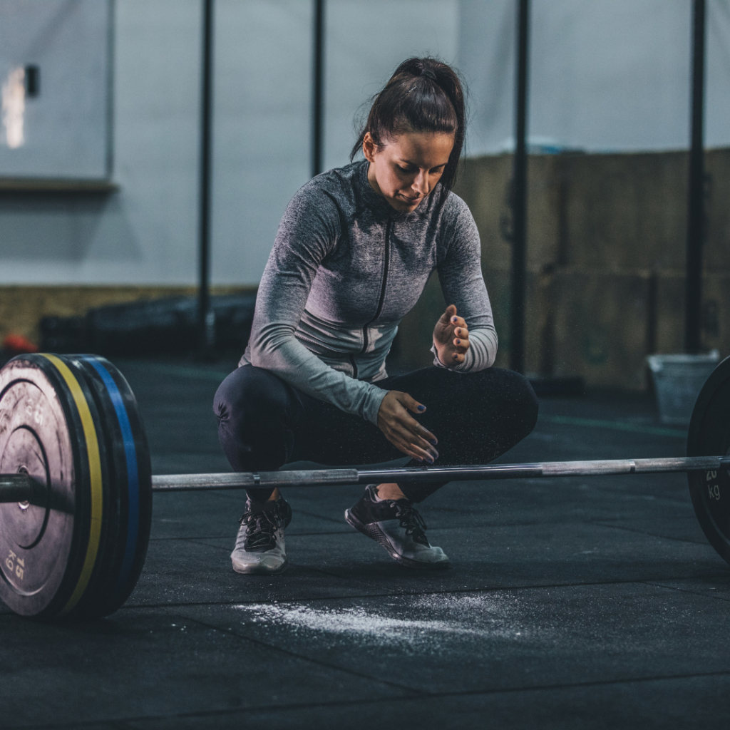 woman putting chalk on her hands before deadlifting